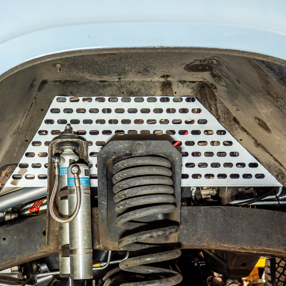 Bronze-colored vented wheel well panel with ribbed texture, side view