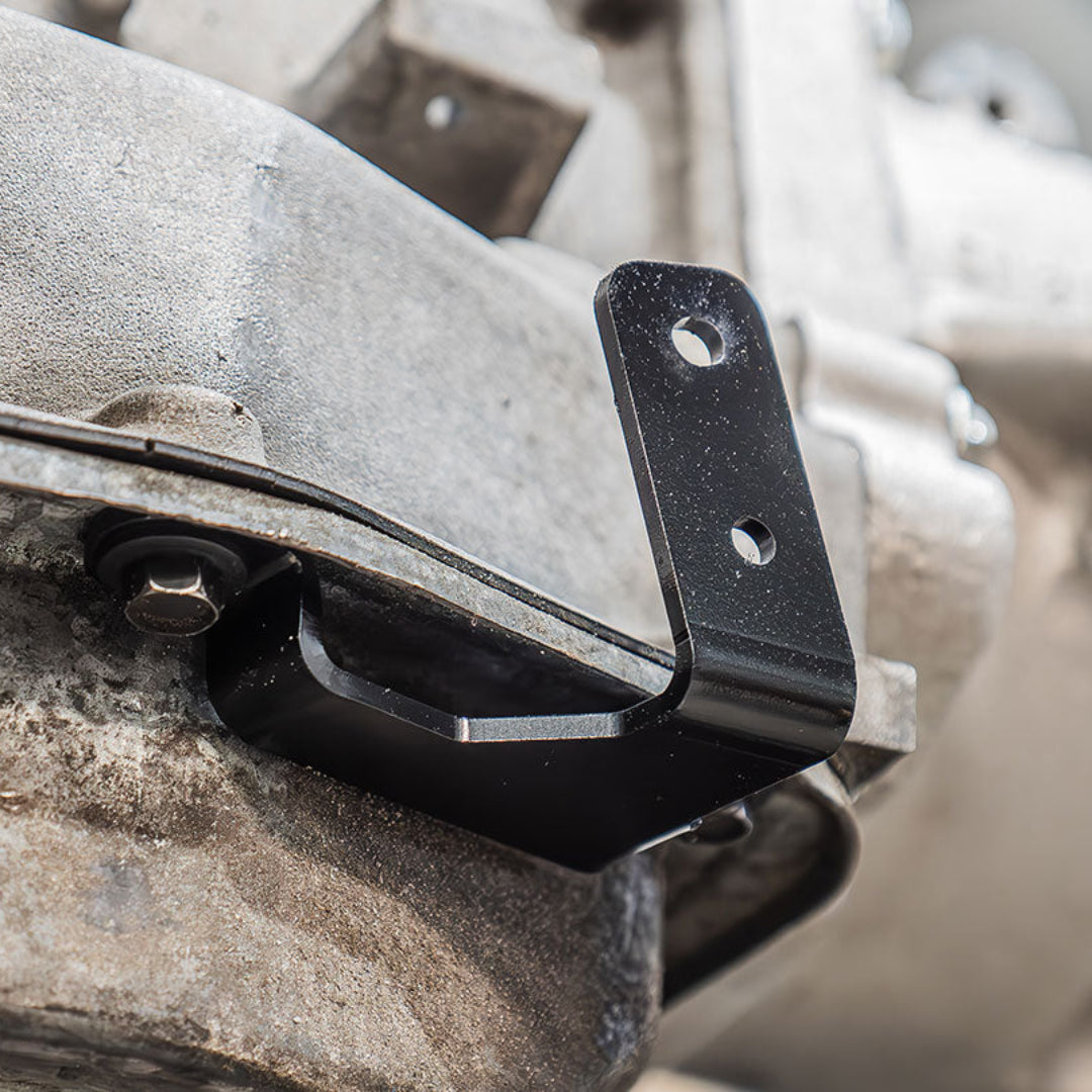 Metal cable shifter bracket with mounting holes and adjustment slots, front view