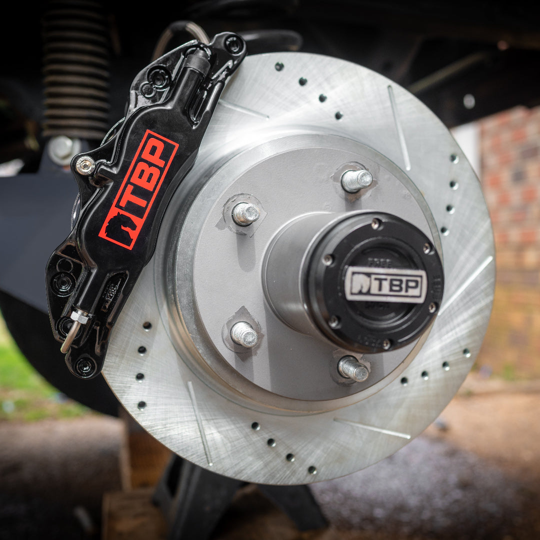 Red powder-coated big brake kit with drilled rotors and multi-piston calipers, front view