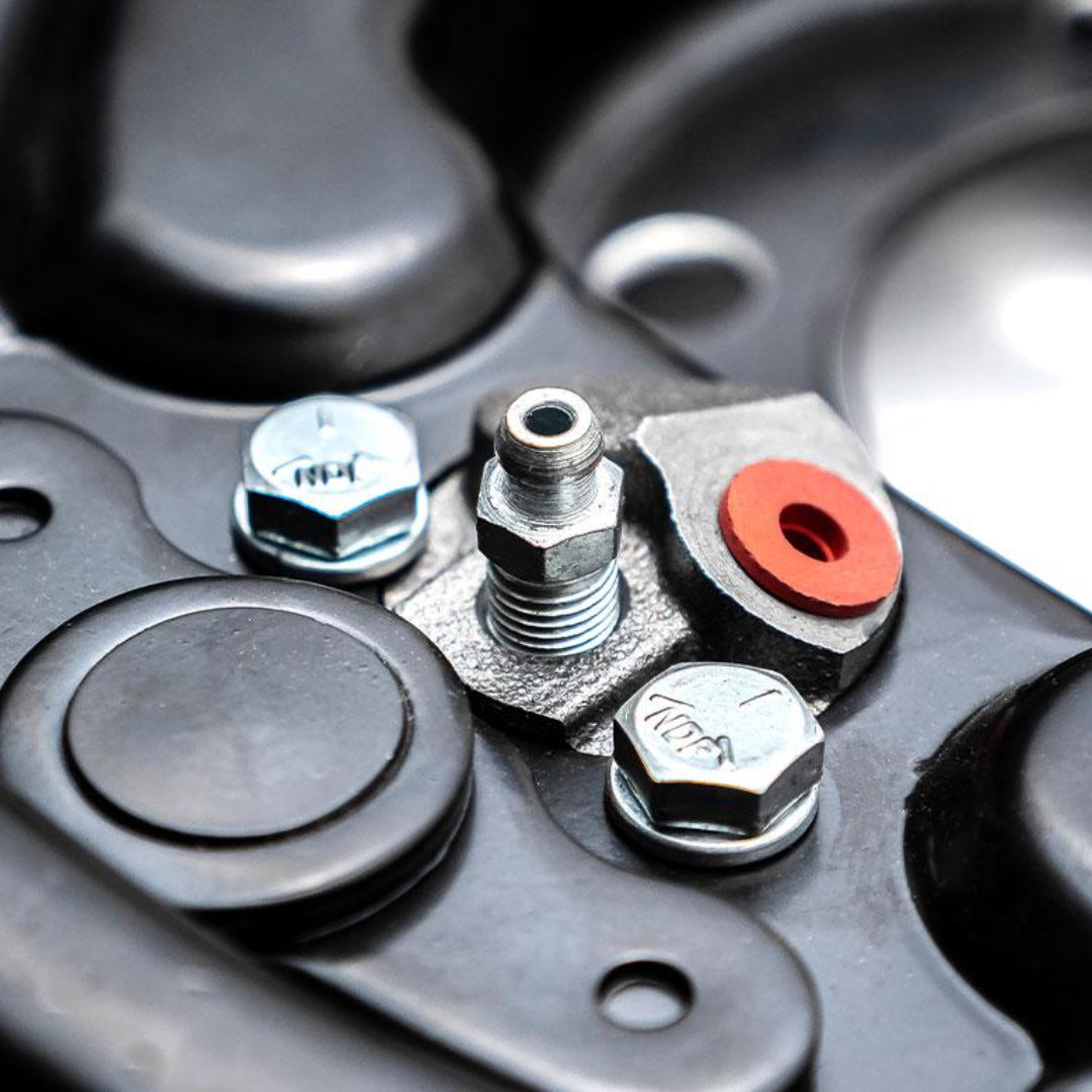 Steel drum brake backing plates with mounting holes and hardware, rear view