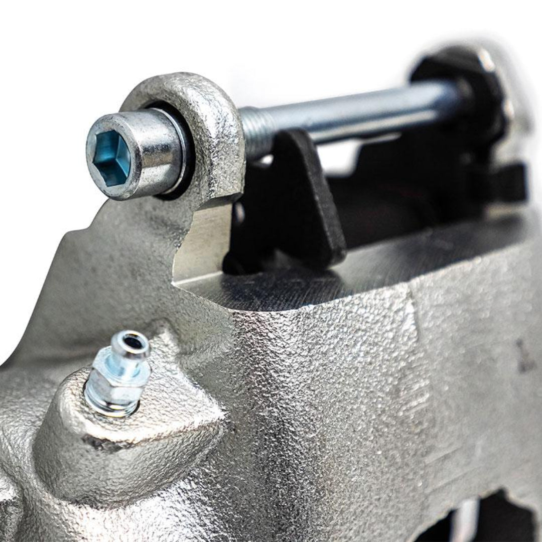 Silver front brake caliper with pads for disc conversion, passenger side view