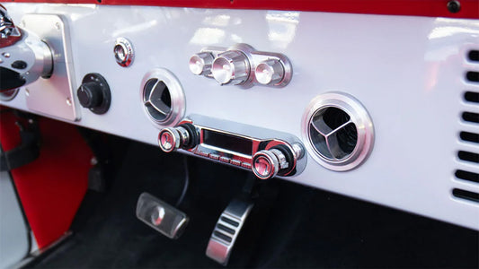 Vintage-style car radio with chrome knobs and orange display, front view