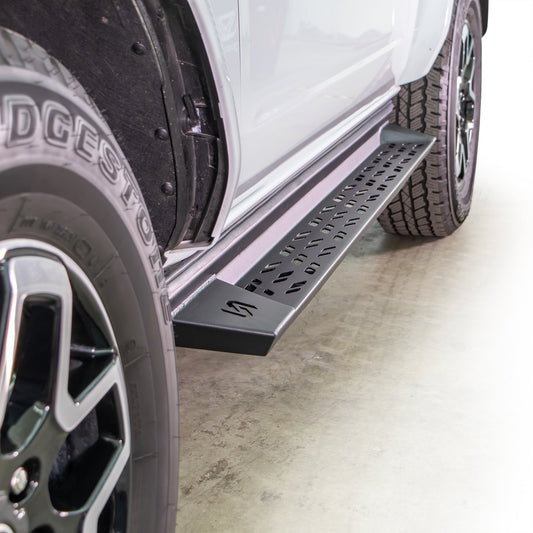 Black powder-coated steel side steps for Ford Bronco, angled view with textured tread surface
