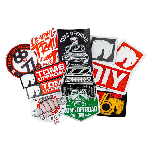 White TOMS OFFROAD sticker with black lettering, detail shot
