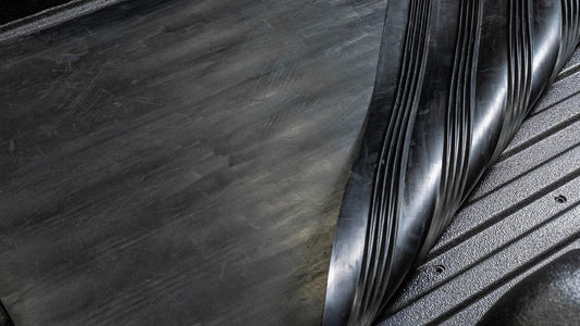 Black rubber floor mat with textured surface and raised edges, rear section